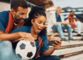Football fan checking match scores and fixtures on a smartphone